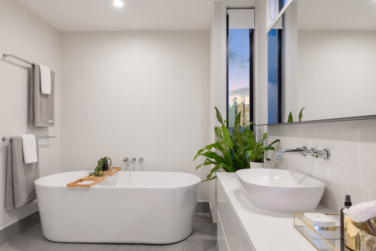 Baño tipo spa con microcemento, madera, luz cálida y plantas naturales