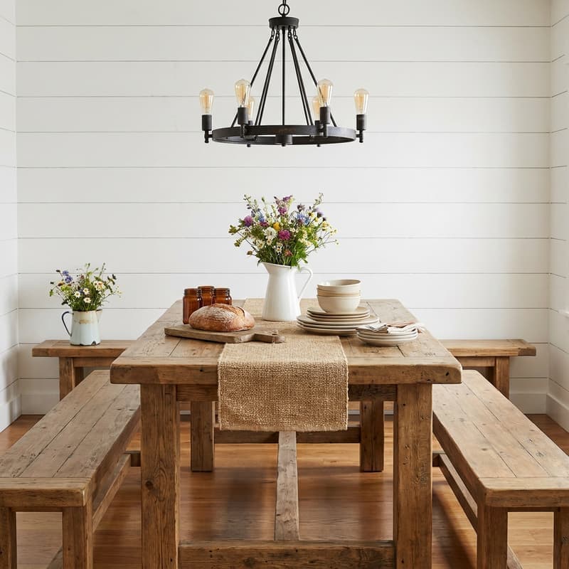 Comedor rústico farmhouse con mesa de madera gruesa, bancas largas, pared shiplap blanca, lámpara de hierro con bombillas Edison y flores silvestres