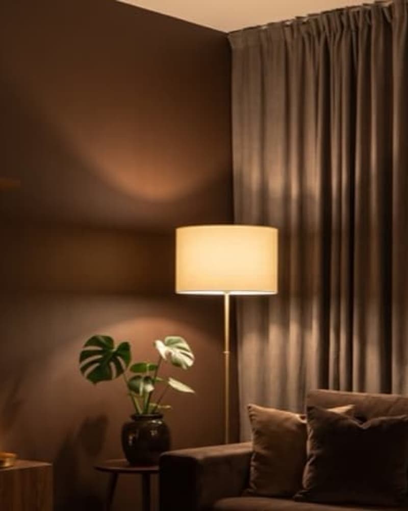 Sala moderna con paleta oscura, sofá gris y acentos metálicos